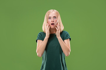 Image showing Beautiful woman looking suprised isolated on green