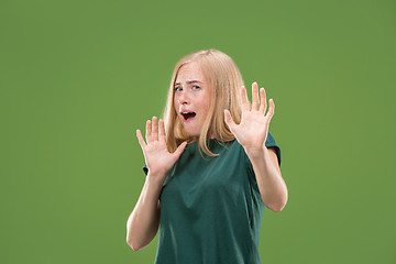 Image showing Portrait of the scared woman on green