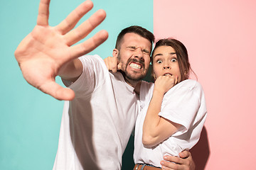 Image showing Portrait of the scared man and woman on pink and blue