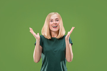 Image showing Beautiful woman looking suprised isolated on green