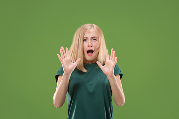 Image showing Portrait of the scared woman on green