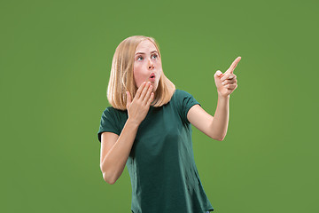 Image showing Beautiful woman looking suprised isolated on green