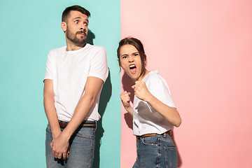 Image showing The young emotional angry woman on pink studio background