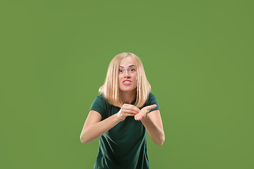 Image showing Beautiful female half-length portrait isolated on green studio backgroud. The young emotional surprised woman