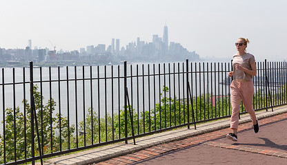 Image showing Healthy lifestyle. Woman is jogging on Hamilton ave by Hamilton park, New Jersey. Manhattan of New York City in the background.