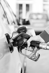 Image showing Closeup of mans hand pumping gasoline fuel in car at gas station.