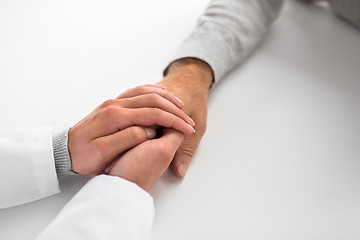 Image showing close up of doctor holding senior patient hand