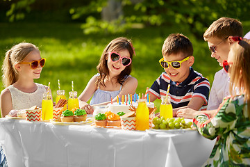 Image showing happy kids with cake on birthday party in summer