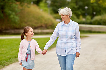 Image showing grandmother and granddaughter walking at park