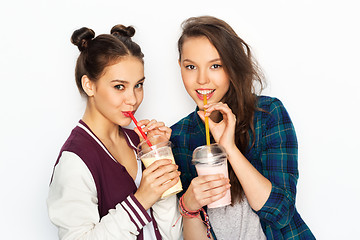 Image showing happy teenage girls drinking milk shakes