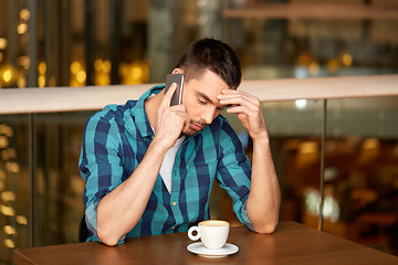 Image showing man with coffee calling smartphone at restaurant