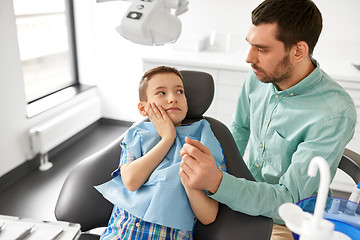 Image showing father supporting son at dental clinic