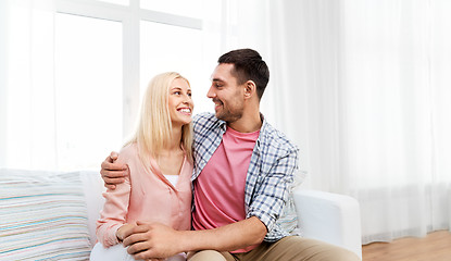 Image showing smiling happy couple hugging on sofa at home