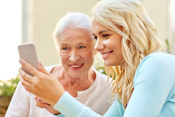 Image showing daughter and senior mother with smartphone outdoor