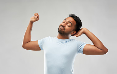 Image showing indian man stretching over grey background