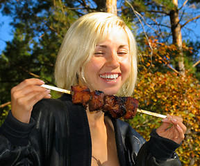 Image showing Smiling girl with shashlik