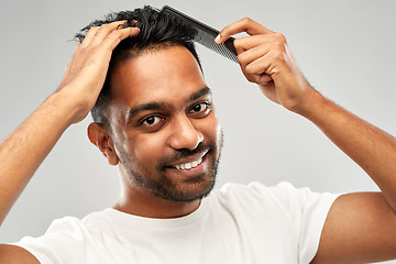 Image showing happy indian man brushing hair with comb