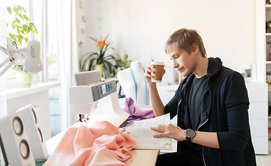 Image showing fashion designer with coffee and book at studio