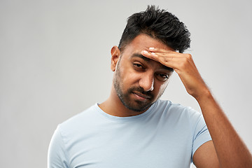 Image showing unhappy indian man suffering from headache