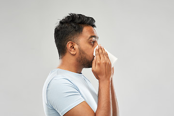 Image showing indian man with paper napkin blowing nose