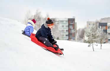 Image showing kids sliding on sleds down snow hill in winter