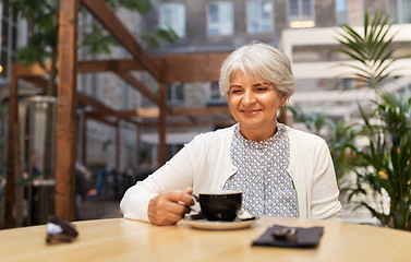 Image showing senior woman drinking coffee at street cafe