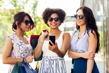 Image showing women with smartphones and shopping bags in city