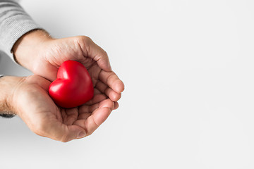 Image showing cupped senior man hands with red heart shape