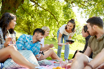 Image showing friends with drinks and food at picnic in park