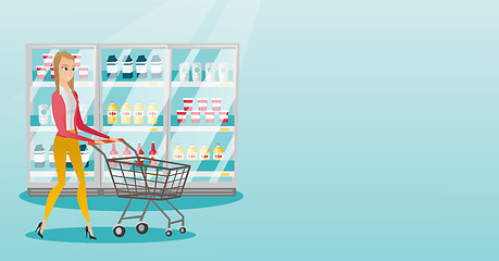 Image showing Young caucasian woman with supermarket trolley.