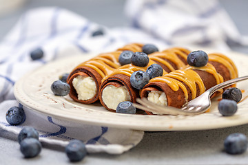 Image showing Delicate chocolate crepes with sweet curd filling.
