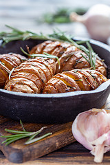 Image showing Potatoes in their skins baked with rosemary.