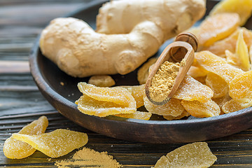 Image showing Ginger root and candied ginger on a wooden plate.