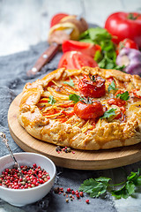 Image showing Open pie with potatoes, bacon, onions and tomatoes.