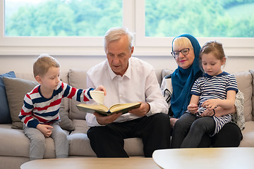 Image showing modern muslim grandparents with grandchildren reading Quran