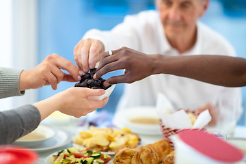 Image showing modern multiethnic muslim family sharing a bowl of dates