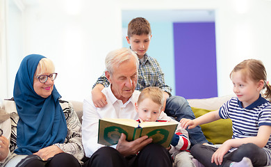 Image showing modern muslim grandparents with grandchildren reading Quran