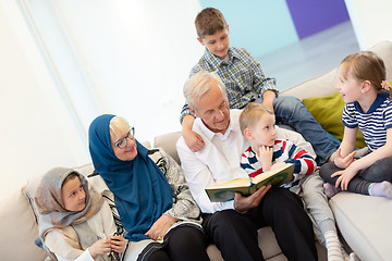 Image showing modern muslim grandparents with grandchildren reading Quran