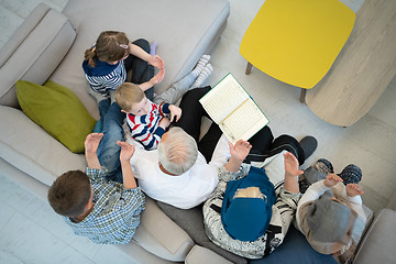 Image showing top view of modern muslim grandparents with grandchildren readin