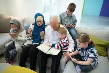 Image showing modern muslim grandparents with grandchildren reading Quran