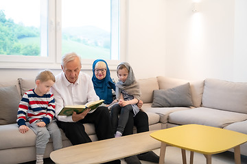 Image showing modern muslim grandparents with grandchildren reading Quran