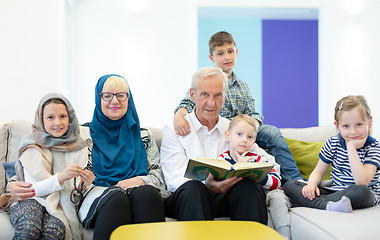 Image showing modern muslim grandparents with grandchildren reading Quran