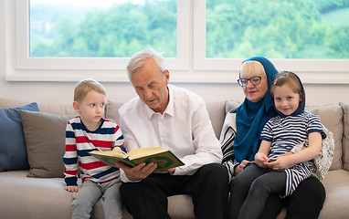 Image showing modern muslim grandparents with grandchildren reading Quran