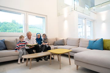 Image showing modern muslim grandparents with grandchildren reading Quran