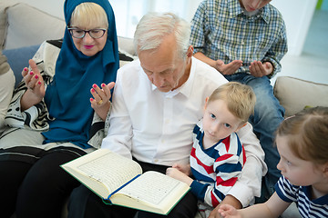 Image showing modern muslim grandparents with grandchildren reading Quran