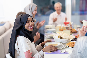 Image showing black modern muslim woman enjoying iftar dinner with family