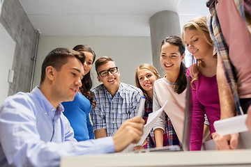 Image showing students and teacher with papers and laptop