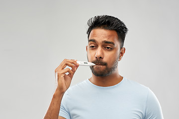 Image showing man measuring oral temperature by thermometer