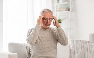 Image showing senior man suffering from headache at home