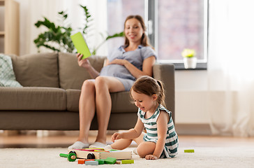 Image showing happy baby girl playing with toy blocks at home